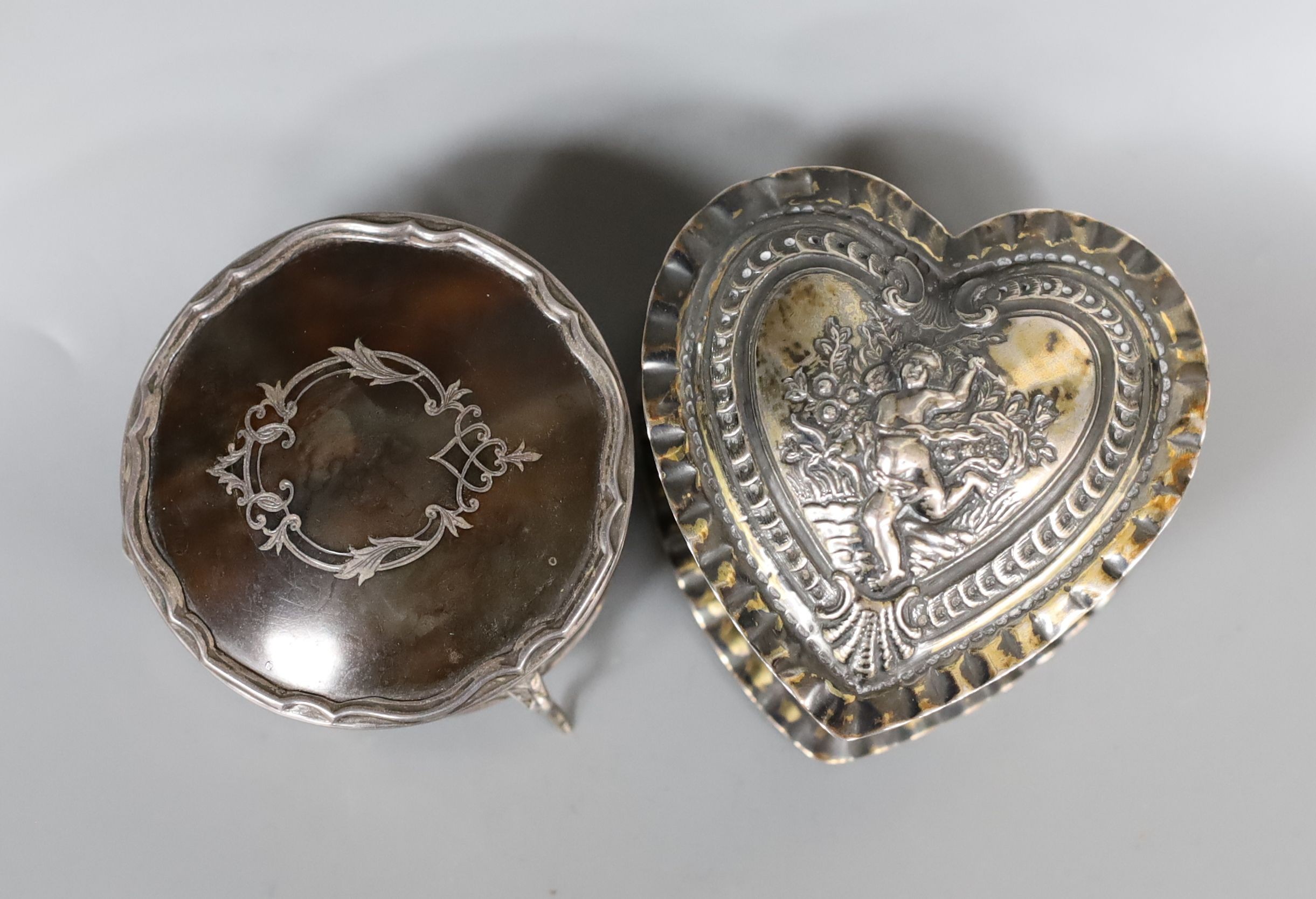 A George V silver and tortoiseshell pique circular trinket box, 71mm and a late Victorian embossed silver heart shaped box, import marks for London, 1888, 80mm.